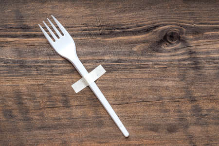 a plastic disposable fork is fixed against the wall with adhesive tape. use as a last resortの写真素材