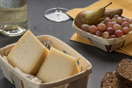 still life with food, cheeses and fruits for display on a dark surface. cheese setsの写真素材