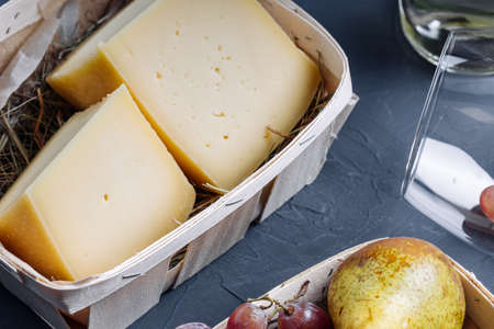 flat top view of cheese in a wooden basket and fruits on the table. table decorationの写真素材