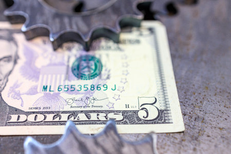 steel cogs gears and money on the background of a rough metal surface. machinery industryの写真素材