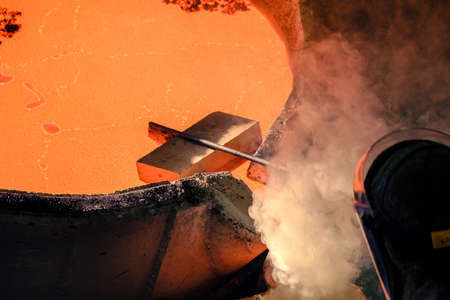 a brick at the edge of a vat with molten metal, floats on the surface so that it does not overflow....