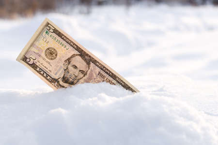 money sticking out of the snow, winter money in a snowdriftの写真素材