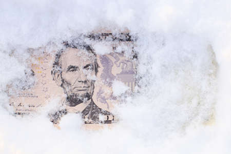 five dollars covered with snow, a portrait of the president can be seen from under the snow. money...