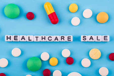 medical drugs and pills on a blue background with the inscription healthcare. marketable healthcare...