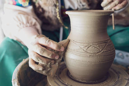 drawing patterns on a rotating jug with wooden tools. old technology for making dishes. rest during...