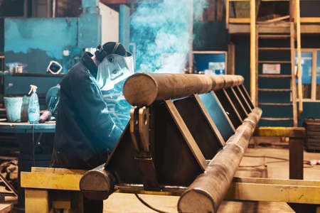 a welder at work at work. reflections of welding and smoke. welder's jobの写真素材