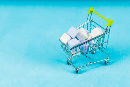 trolley from the supermarket with cubes inside. background blue. after shopping. rash purchasesの写真素材
