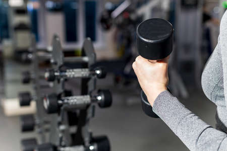 the girl is holding a dumbbell, the background is blurred. lesson in the hallの写真素材