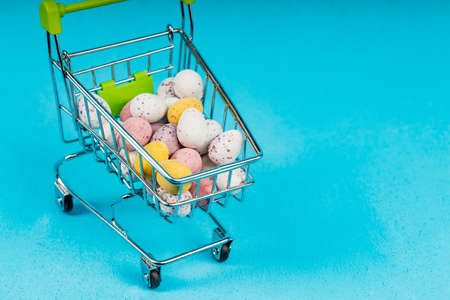 in a cart from a supermarket eggs of different colors. purchase of eggs.の写真素材