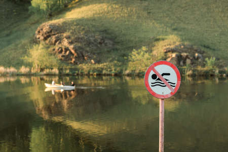 summer day on the river, swimming is prohibited sign. boat on the river in summerの写真素材