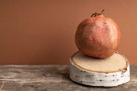 pomegranate on a wooden birch pedestal. carved part of birch and fruitの写真素材