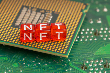 between the microcircuits and the processor are red cubes with the letters NFT. blockchain tokensの写真素材