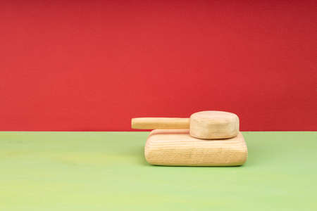 homemade wooden tank on a red background and a green base. toy military equipmentの写真素材