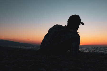 silhouette of a man who lies and rests on the seashore. coastline and manの写真素材