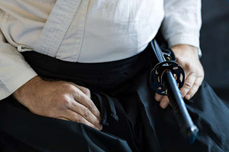 hands on the feet of a warrior who practices martial arts, a sword in a scabbard.の写真素材