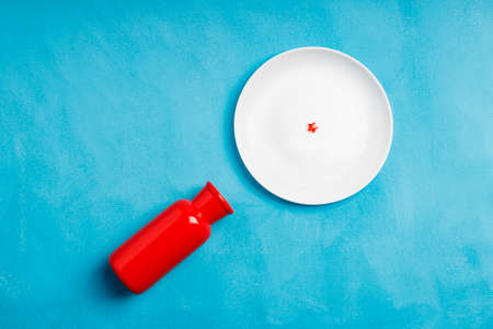 a red vase and a white plate, a plastic star in the center of the plate. blue red and white colorsの写真素材