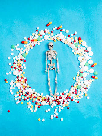 human skeleton medical drugs in the form of tablets around the skeleton. too many drugs people take in their livesの写真素材
