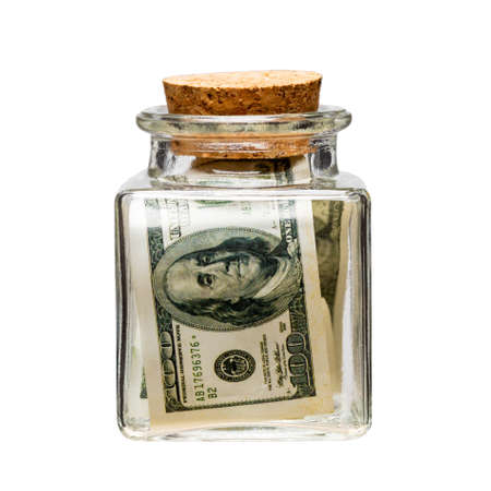 a glass square jar closed with a cork, inside the jar is money. keeping dollars in a bankの写真素材