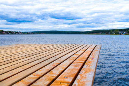 pier on the lake empty without objects, summer cloudy day. clouds on the horizonの写真素材