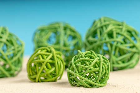 green decorative wicker balls on the sand. balls and sandの写真素材
