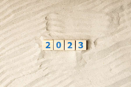 waves and bumps on the sand, wooden cubes with the inscription 2023. year on the sand, drought and...