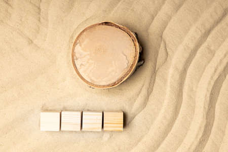 top view on sand, pine wood stump and wooden cubes empty four pieces. waves of sand and a round stumpの写真素材