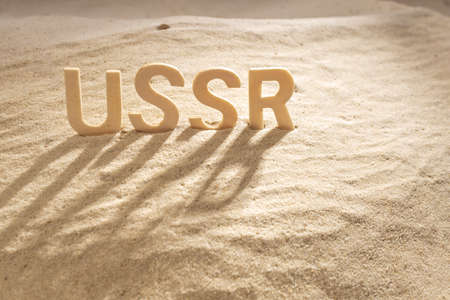 wooden letters on the sand, the past name of Russia is written Ussr. Land stuck in the sandの写真素材