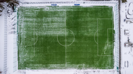 aerial photography top view of the winter football field. green field and white snowの写真素材