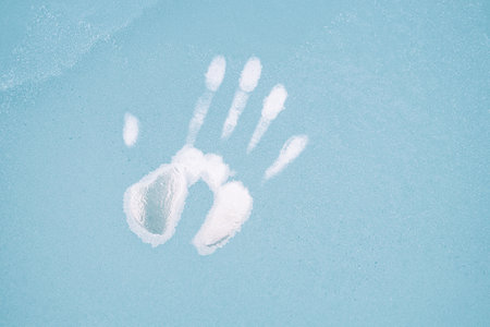 trace on the frozen glass from the right hand. the imprint of a man's hand on an insole covered with hoarfrostの写真素材