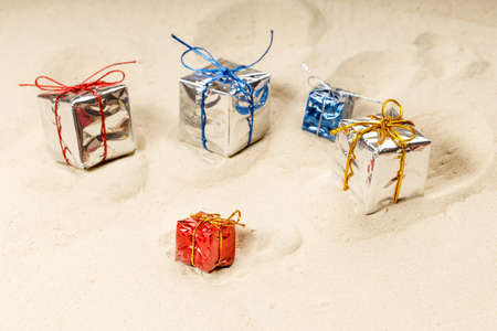 gift wrappings are scattered on the sand. gifts got dusty