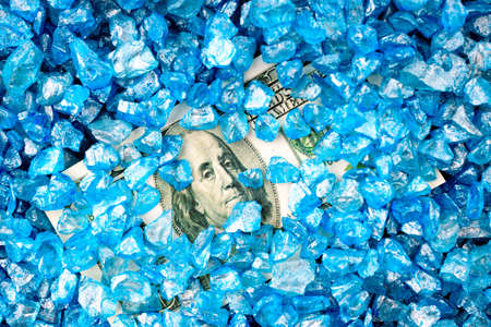 one hundred dollars under blue stones, stones texture, solid background. money under decorative...
