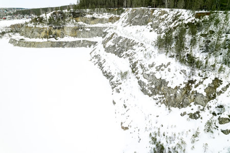 aerial photography of winter terrain quarry in the forest. stones and stone wall