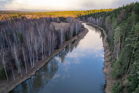 drone view of the river in a forest area, a turn of the river with a reflection of the forest in the...