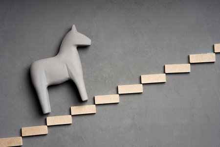 steps and a horse, a gray toy animal climbing up. moving up stairsの写真素材