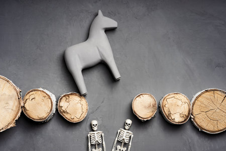 a toy horse jumps over an obstacle, there are two skeletons below the bridge. overcoming barriers. jump over a hole in the bridge if you fall down deathの写真素材
