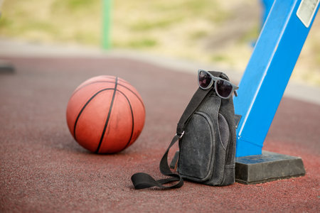 basketball ball and bag on outdoor sports ground. playing basketball instead of lessonsの写真素材