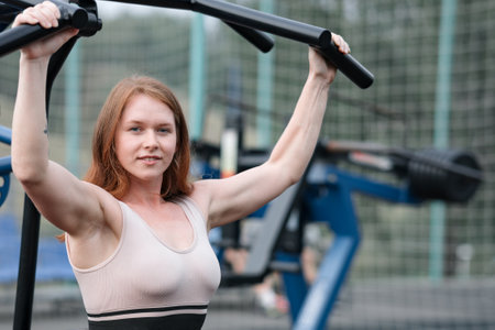 strong girl doing exercises on the simulator. outdoor sports on the sports ground