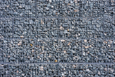 a net holding stones, a wall of stones. background mesh and stones, construction workの写真素材