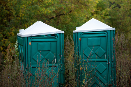 two broken plastic toilets outside, old broken toiletsの写真素材
