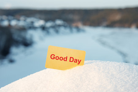 on a snowy hill there is a yellow card in the snow, a yellow empty card for the inscription sticking out of the snow. winter dayの写真素材