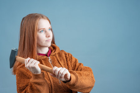 a hammer in the hands of a woman who looks up, a determined woman with a tool. smash and score