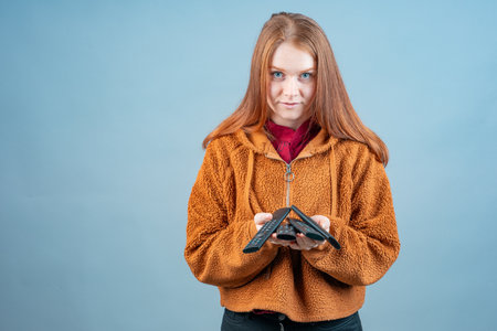 a young woman holds several TV remotes with both hands. there are a lot of TVs in the apartment