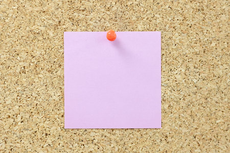 A pink sticker to remind you of important things is attached to a button on the board. a reminder of...