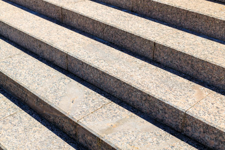 A set of stone steps with a gray color. The steps are arranged in a way that they are not very steep, making it easy for people to climb them. The steps are also quite narrowの写真素材