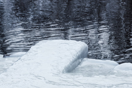 icing of the riverbank and bridge. It's slippery in winter by the pond