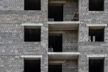 A building with many windows and a lot of empty space. The building is made of bricks and has a very industrial lookの写真素材