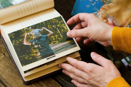 Photo printing concept. Female hands adding printed photo to picture album.の写真素材