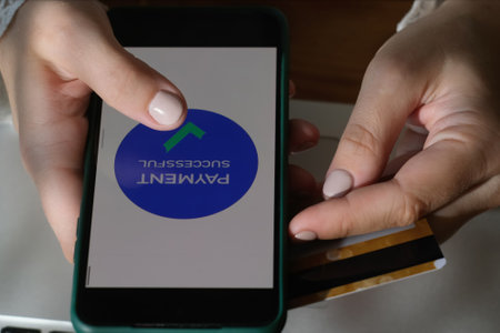 Hands make money transfer using smartphone and plastic bank card