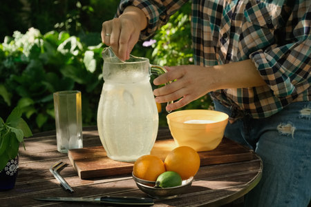 Person making lemonade drink outdoors.の写真素材