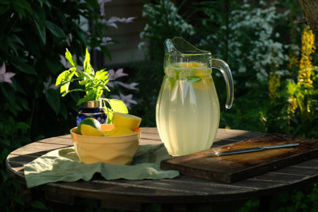 Jug of lemonade drink on wooden garden table in summerの写真素材